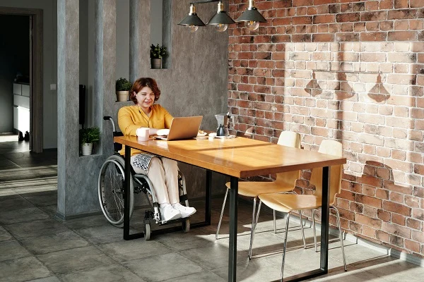 Person im Rollstuhl arbeitet am Laptop