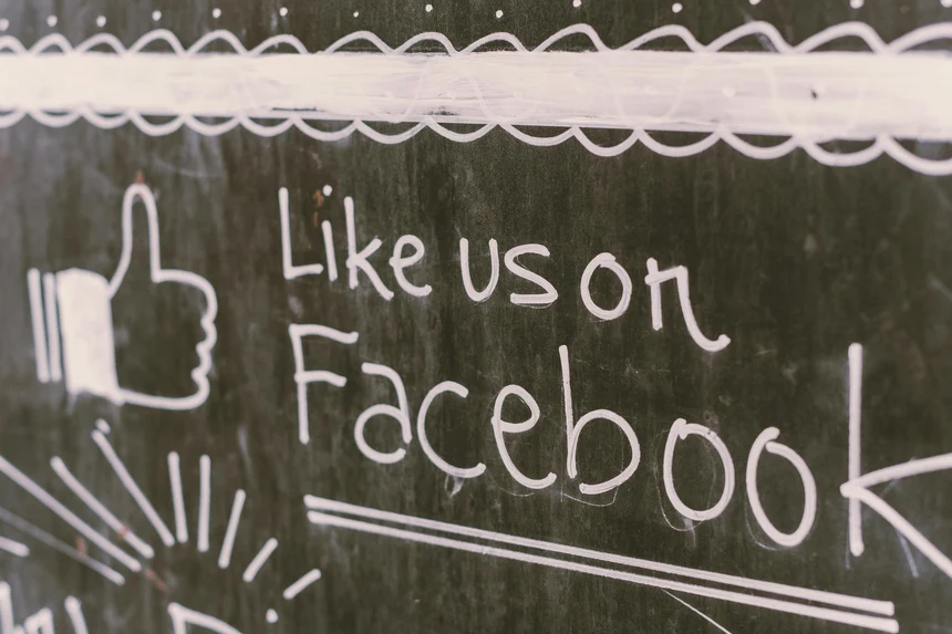 Tafel mit der Kreideaufschrift "Like us at facebook"