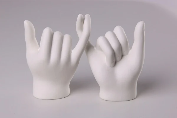 zwei Handmodelle, bei denen sich die kleinen Finger einhaken