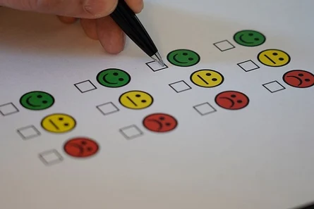 Umfrage: grüner lachender Smiley, gelber neutraler Smiley, roter trauriger Smiley mit Feld zum Ankreuzen darunter; davon vier Reien untereinander
